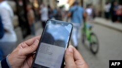 Una mujer chequea las opciones para conectarse a Internet en Cuba. SNet fue creada de manera informal, hace 15 años, para facilitar el acceso a la red. (Yamil Lage/AFP).