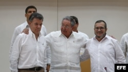 El presidente de Colombia, Juan Manuel Santos; el máximo líder de las FARC; Rodrigo Londoño alias "Timochenko"; y el gobernante de Cuba, Raúl Castro, participan en el acto para presentar un acuerdo en los diálogos de paz en La Habana.