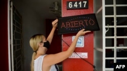 Foto Archivo. Una joven cubana se dispone a abrir su negocio.