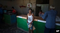 Una mujer compra pan por la libreta de racionamiento en una bodega en San Nicolás, el 19 de mayo de 2023. AP Photo/Ramon Espinosa