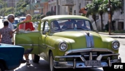 Varios turistas suben a un auto con la bandera de Estados Unidos en La Habana. (Archivo)