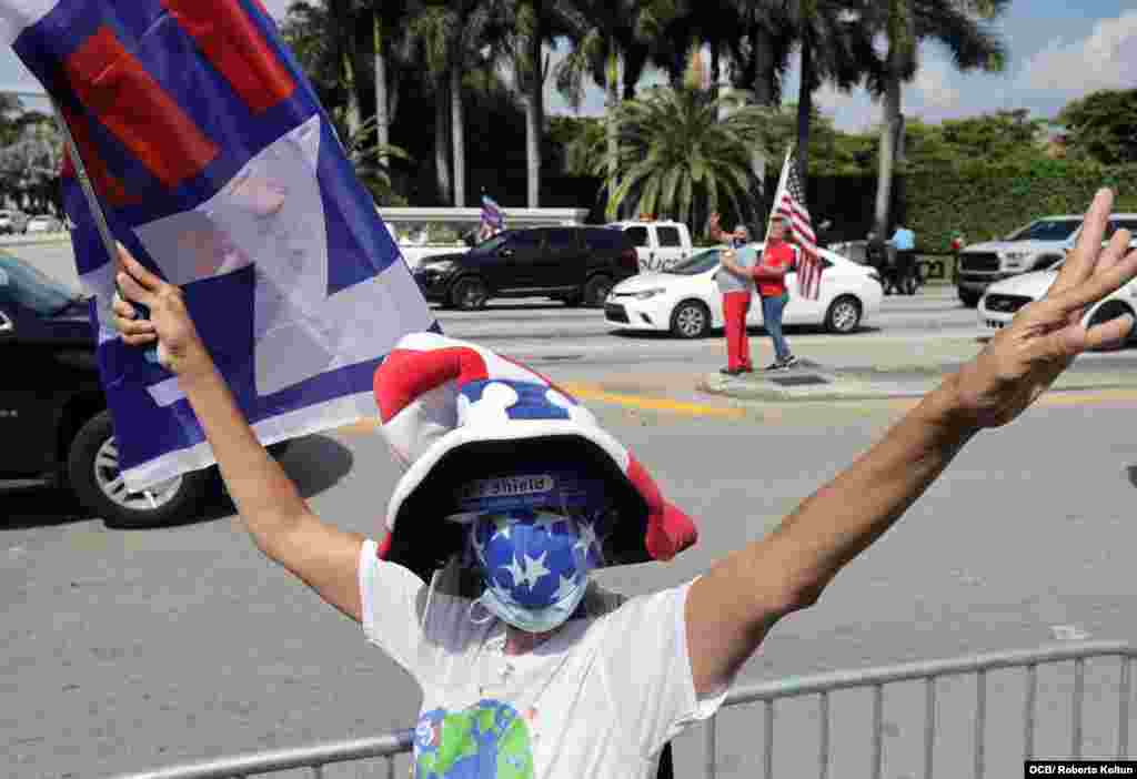 Seguidor de Joe Biden y Kamala Harris sostiene un cartel en su apoyo durante visita del presidente Trump al Sur de Florida.