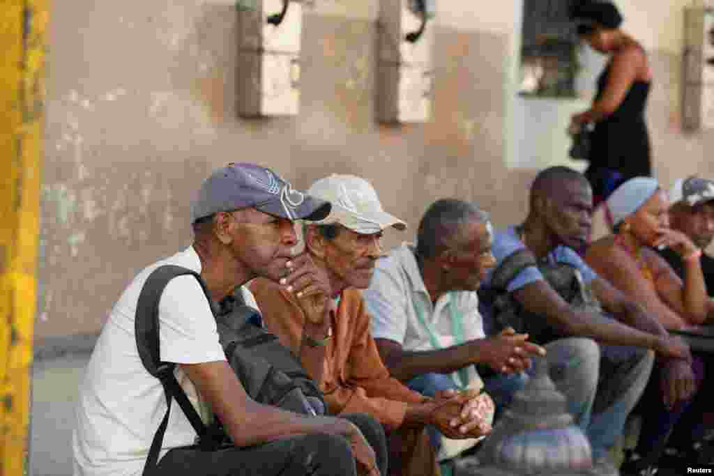 La gente se sienta en una acera en una parada de autobús, en La Habana, Cuba, 4 de septiembre de 2024. REUTERS/Norlys Pérez