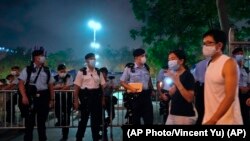 Agentes de policía vigilan los alrededores del Victoria Park, en Hong Kong, durante una vigilia para conmemorar el 32 aniversario de la represión militar contra el movimiento estudiantil en la plaza Tiananmen de Beijing. (AP/Vincent Yu).