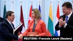 Bruno Rodríguez, saluda a la entonces jefa de política exterior de la UE, Federica Mogherini, junto al canciller de Eslovaquia, Miroslav Lajcak, tras firmar el Acuerdo de Diálogo Político y Cooperación, en Bruselas, el 12 de diciembre de 2016.