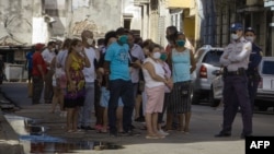 La policía controla la cola en una de las nuevas tiendas en dólares. (Adalberto ROQUE / AFP)