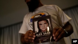 Un hombre sostiene un cartel que pide la libertad del empresario colombiano y enviado especial venezolano Alex Saab.