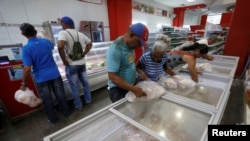 Cubanos compran pollo congelado en un supermercado de La Habana. 