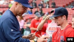 El entrenador de los Indios de Cleveland Terry Francona firma pelotas de béisbol a seguidores de los Medias Rojas de Boston.