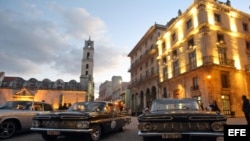 Varios autos clásicos permanecen parqueados en una plaza en la Habana Vieja.