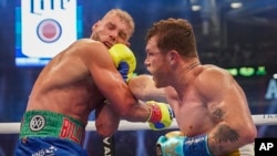 El mexicano Saúl "Canelo" Álvarez, asesta un puñetazo al británico Billy Joe Saunders, el sábado 8 de mayo de 2021, en una pelea por el cetro de los supermedianos, en Arlington, Texas (AP Foto/Jeffrey McWhorter)